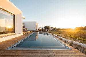 Swimming,Pool,With,Wooden,Deck,View,On,Modern,Villa
